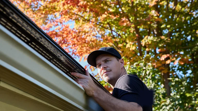 Installer checking an Alu-Rex gutter guard on a West Kootenay home