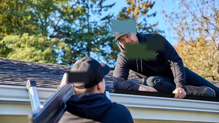 Team installing seamless gutters on a Castlegar rooftop